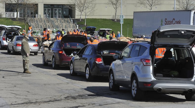 Area food banks have seen a large increase in need as more and more people are laid off due to the coronavirus. Pictured is The Foodbank’s mass food distribution at the Nutter Center. STAFF/MARSHALL GORBY