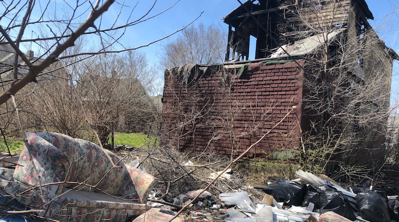 Trash litters a vacant and fire-damaged property in Dayton. CORNELIUS FROLIK / STAFF