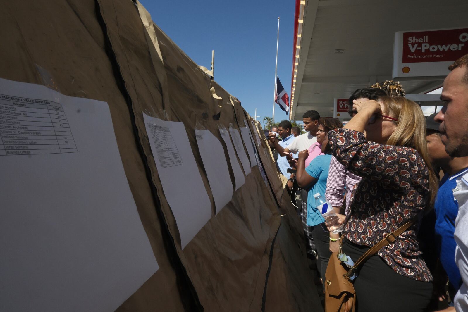 People read lists of survivors as crews search for others trapped at the Jet Set nightclub after its roof collapsed during a merengue concert in Santo Domingo, Dominican Republic, Tuesday, April 8, 2025. (AP Photo/Ricardo Hernandez)
