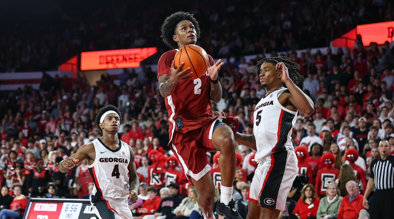 Alabama guard Aden Holloway (2) shoots against Georgia guards Marcus Millender (4) and Jeremiah Wilkinson (5) during the second half of an NCAA college basketball game, Tuesday, March 3, 2026, in Athens, Ga. (AP Photo/Colin Hubbard)