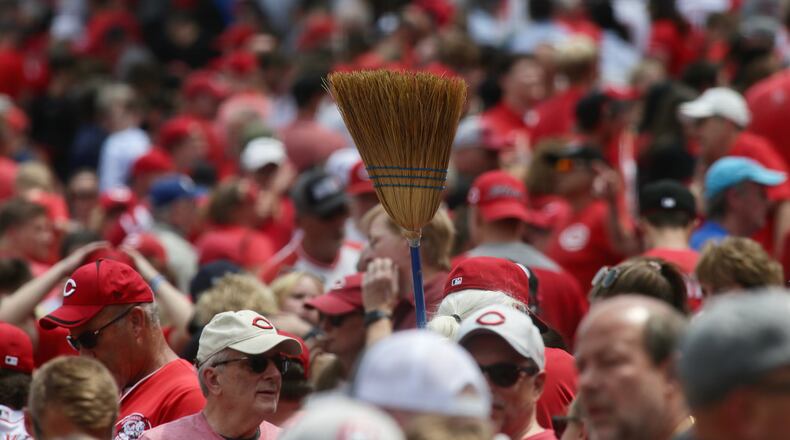 A fan carries a broom after the Reds swept the Rockies on Wednesday, June 21, 2023, at Great American Ball Park in Cincinnati. David Jablonski/Staff