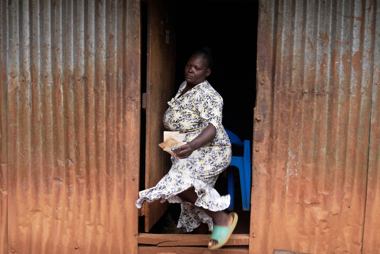 Susan Njeri, 44 years old, whose son Boniface Kariuki was shot at close range by a Kenyan police officer during a protest, walks out of her house in Muranga, Kenya, Wednesday, June 18, 2025. (AP Photo/Brian Inganga)