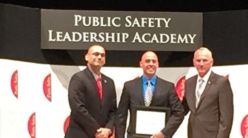 Fairborn Police Department Sgt. Ben Roman, center, poses with Ohio State Highway Patrol Col. Paul Pride, right, and OSHP Lt. Angel Burgos, left, while graduating from the Public Leadership Academy. CONTRIBUTED