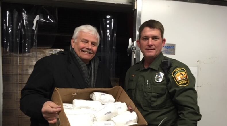 State Wildlife Officer Timothy Rourke and Pastor John Geissler, Agape Food Dist. Center, holding the donated venison.