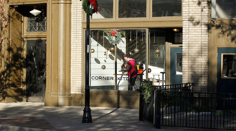 Liddy Vella vacuums the dining area of the Corner Kitchen at the corner of E. Fifth St. and Wayne Avenue. TY GREENLEES / STAFF