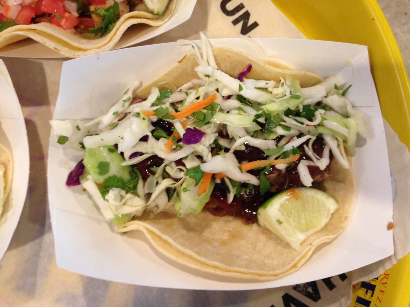 R Taco's BBQ brisket taco features slow roasted brisket with BBQ sauce and slaw.