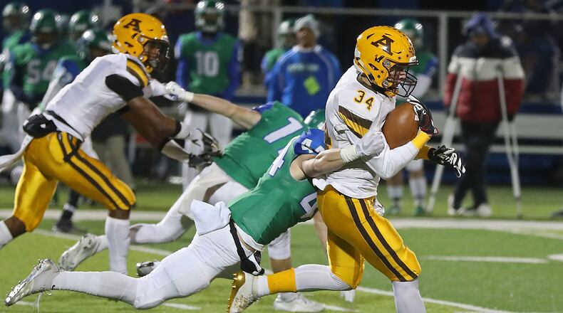 Aldter’s Seth Morris is tackled by CJ’s Cooper Mullins as he carries the ball during Friday’s Division III, Region 12 quarterfinal. BILL LACKEY/STAFF
