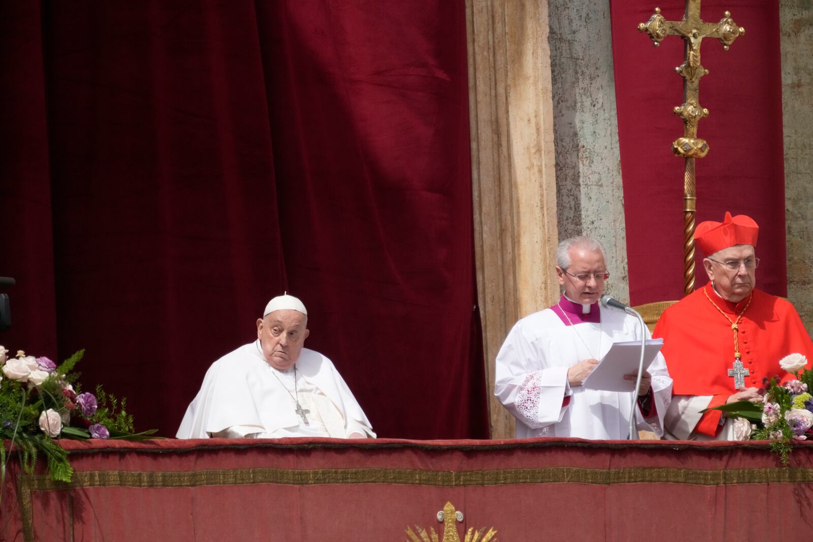 Pope Francis, left, appears on the central lodge of St. Peter's Basilica to bestow the Urbi et Orbi (Latin for to the city and to the world) blessing at the end of the Easter mass presided over by Cardinal Angelo Comastri in St. Peter's Square at the Vatican Sunday, April 20, 2025. (AP Photo/Gregorio Borgia)