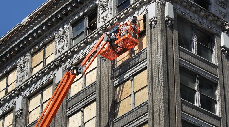 Workers board up windows at the Arcade complex's Commercial Building on Monday, April 22. CHRIS STEWART / STAFF