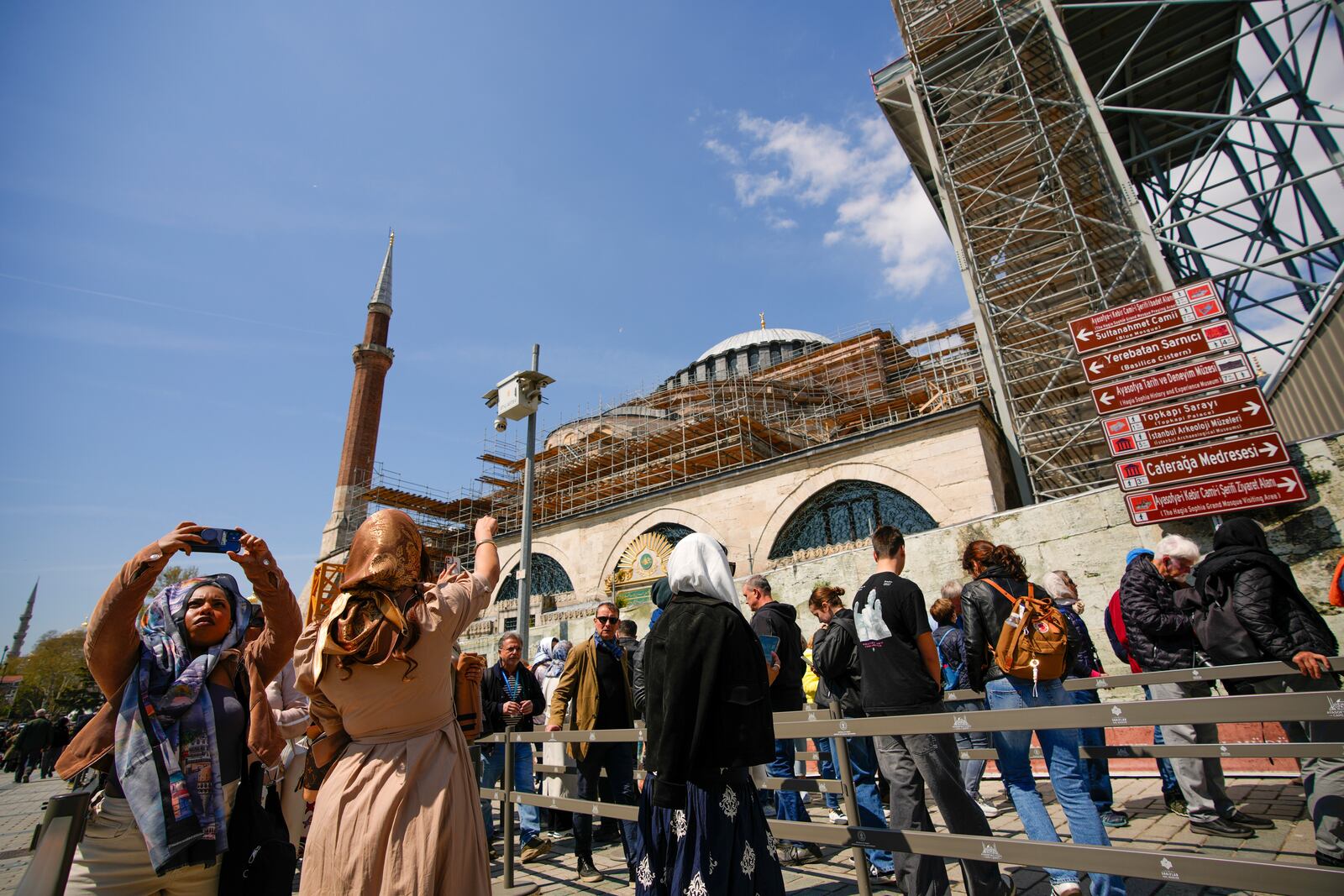 People wait in line to visit Byzantine-era Hagia Sophia mosque next to scaffolds installed for restoration works, in Istanbul, Turkey, Sunday, April 13, 2025. (AP Photo/Emrah Gurel)
