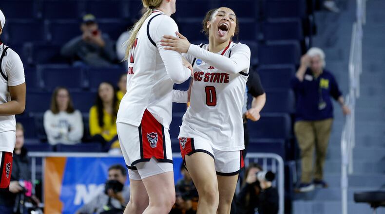 North Carolina State guard Devyn Quigley (0) and forward Maddie Cox, center left, celebrate after defeating Tennessee in the first round of the NCAA college basketball tournament, Friday, March 20, 2026, in Ann Arbor, Mich. (AP Photo/Al Goldis)