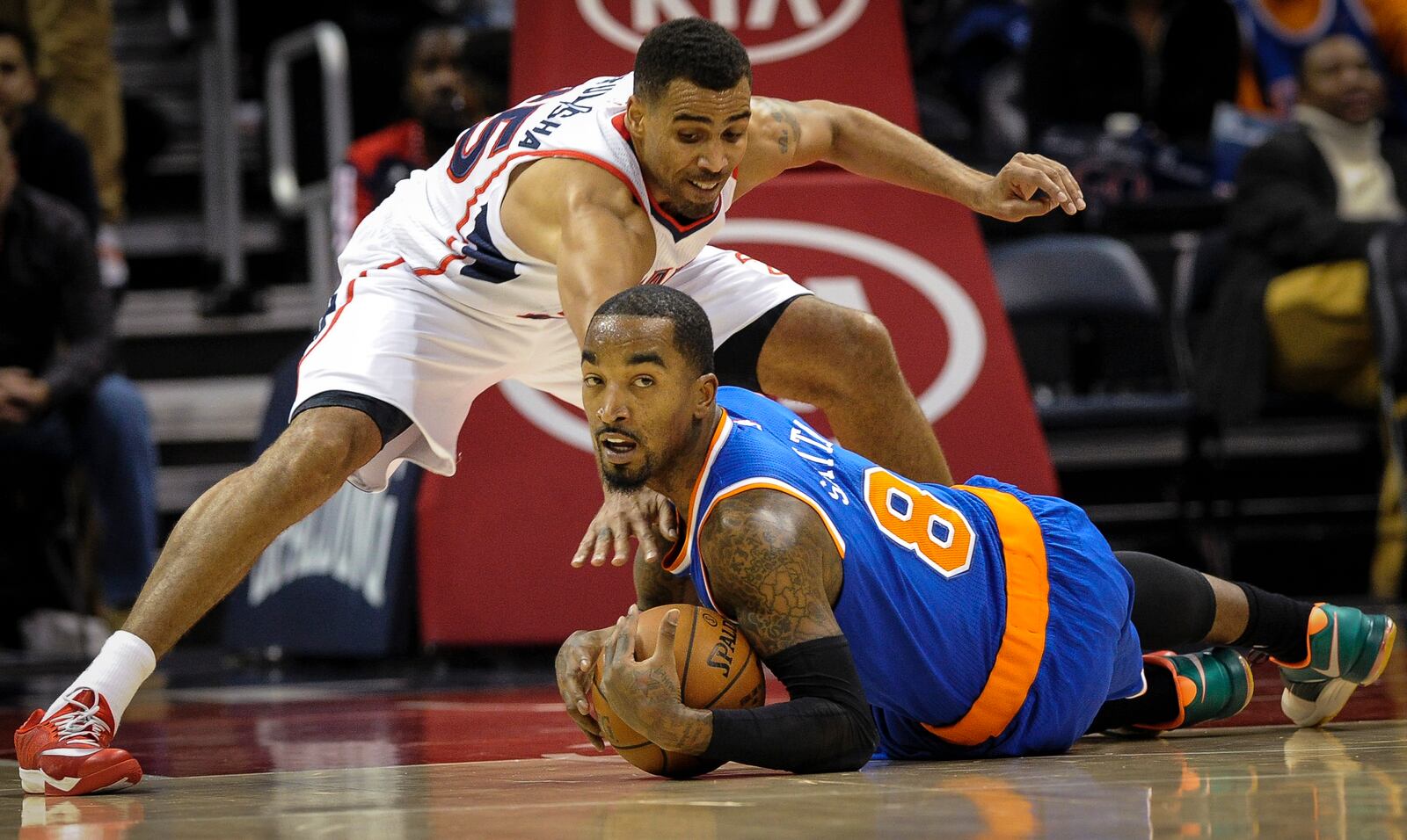 New York Knicks guard J.R. Smith (8) tries to keep a loose ball from Atlanta Hawks guard Thabo Sefolosha, of Switzerland, during the first half of an NBA basketball game, Saturday, Nov. 8, 2014, in Atlanta. (AP Photo/John Amis)