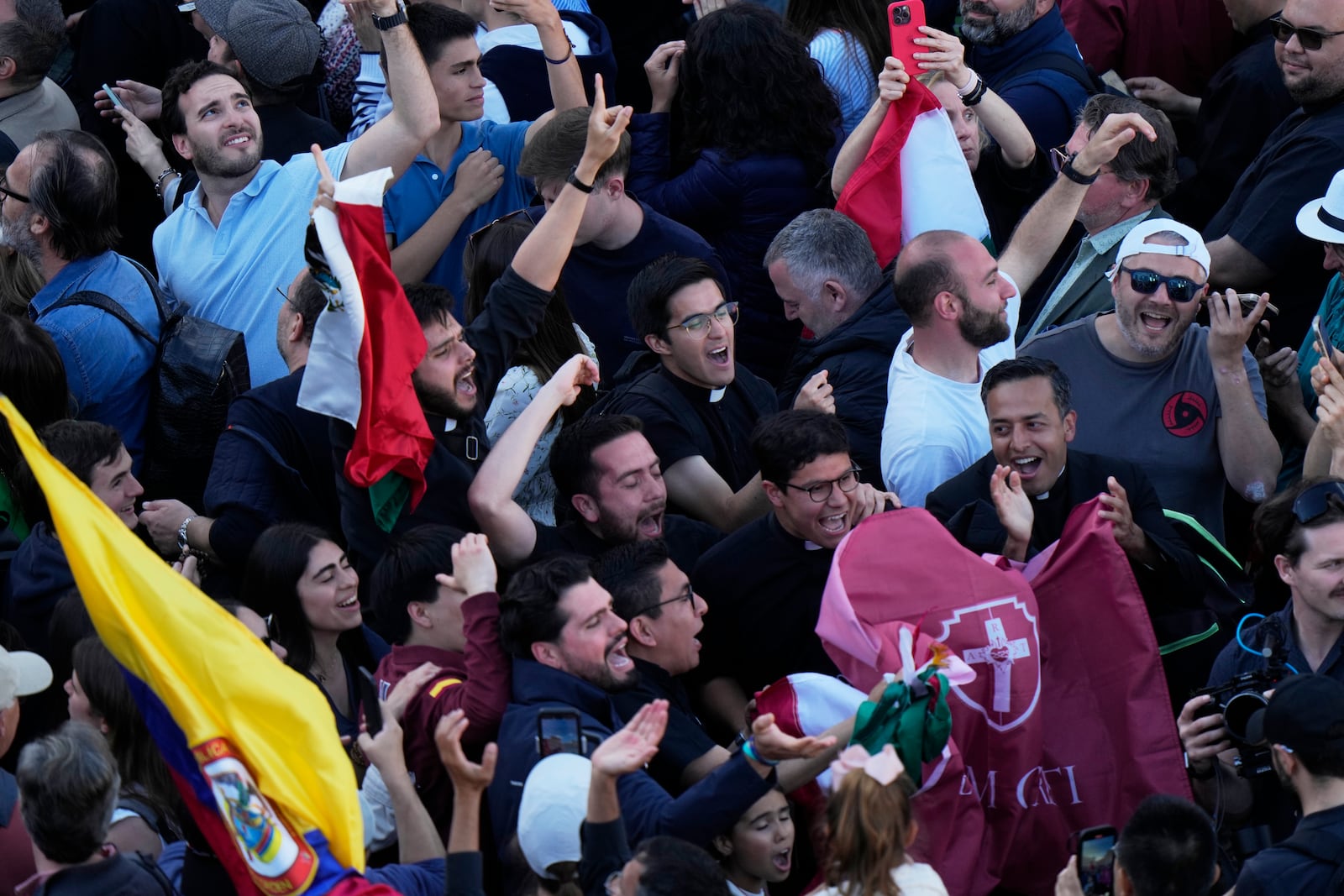 People react as white smoke billows from the chimney of the Sistine Chapel where 133 cardinals are gathering on the second day of the conclave to elect a successor to late Pope Francis, at the Vatican, Thursday, May 8, 2025. (AP Photo/Luca Bruno)