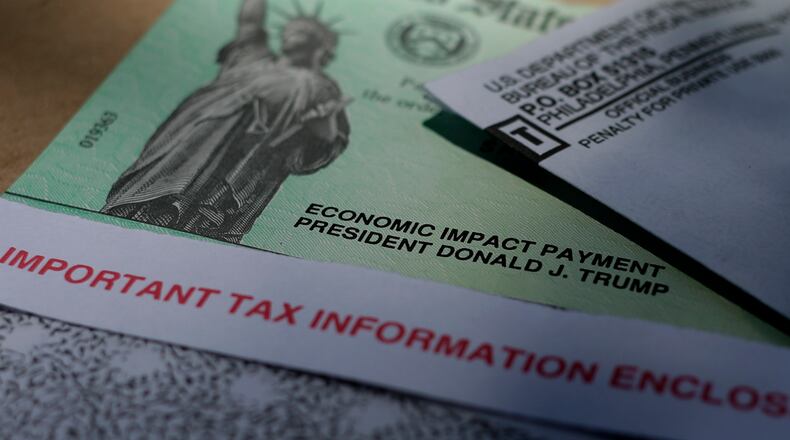 FILE - In this April 23, 2020 file photo, President Donald J.Trump's name is printed on a stimulus check issued by the IRS to help combat the adverse economic effects of the COVID-19 outbreak in San Antonio.  The IRS said that after initial problems, it is getting more of the second round of relief payments to taxpayers. A number of people who filed their taxes with an online preparation service initially found that their economic impact payment did not make it to them directly.   (AP Photo/Eric Gay)