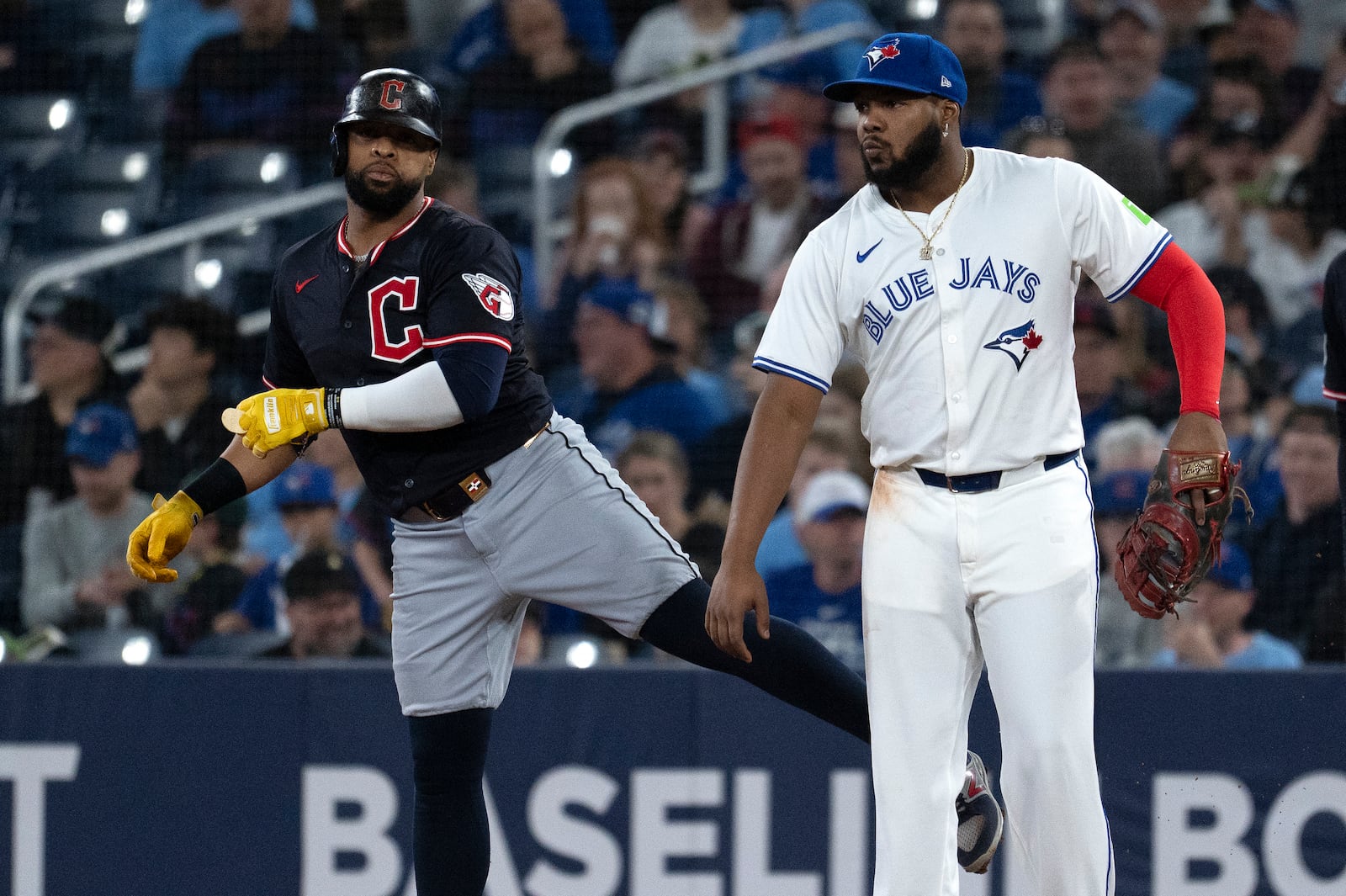 Cleveland Guardians' Carlos Santana, left, jokes with Toronto Blue Jays first baseman Vladimir Guerrero Jr during the first inning of a baseball game in Toronto, Saturday, May 3, 2025. (Jon Blacker/The Canadian Press via AP)