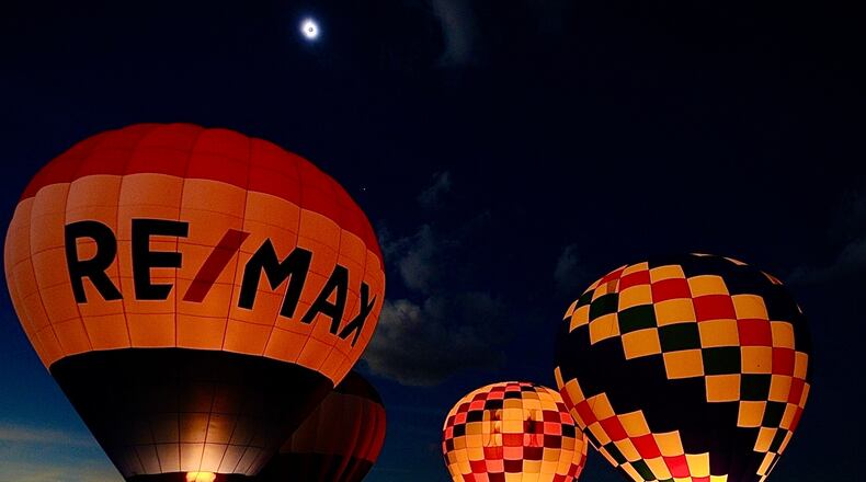 The totality of the solar eclipse (top of the photo) was visible during a balloon glow at the National Museum of the United States Air Force on Monday, April 8, 2024. MARSHALL GORBY / STAFF