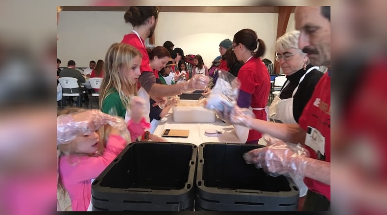 About 60 children and adults helped prepare meals at the First Presbyterian Church in Yellow Springs Thursday Dec. 27, 2018. The goal of the event, hosted by Kid Scouts Inc. and Hunger Van, was to prepare 10,000 meals that will be distributed to people in need. RICHARD WILSON/STAFF