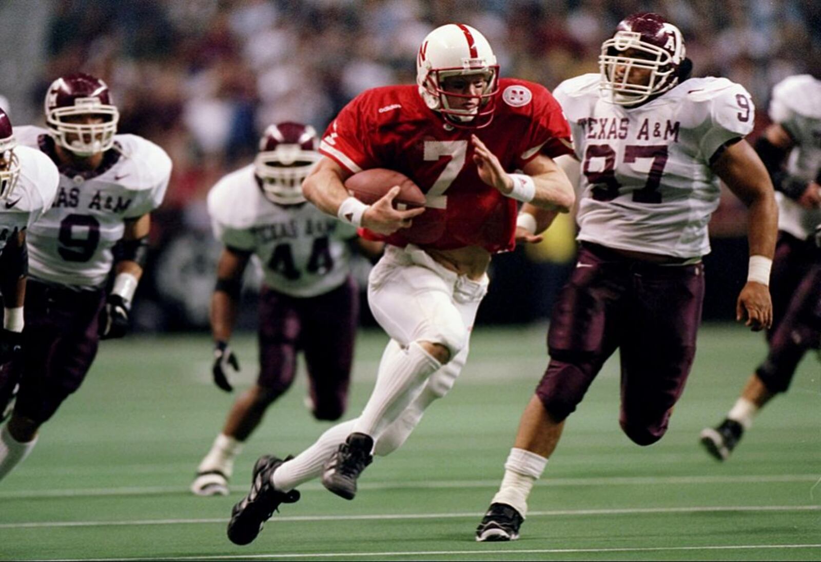 6 Dec 1997:  Quarterback Scott Frost of the Nebraska Cornhuskers runs down the field as nose tackle Marcus Heard of the Texas A&M Aggies chases after him during a game at the Alamodome in San Antonio, Texas.  Nebraska won the game 54-15. Mandatory Credit: