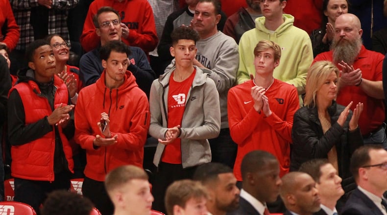 Koby Brea, center, stands behind the Dayton bench next to Lukas Frazier, second from right, during a game against Indiana State on Nov. 9, 2019, at UD Arena. David Jablonski/Staff