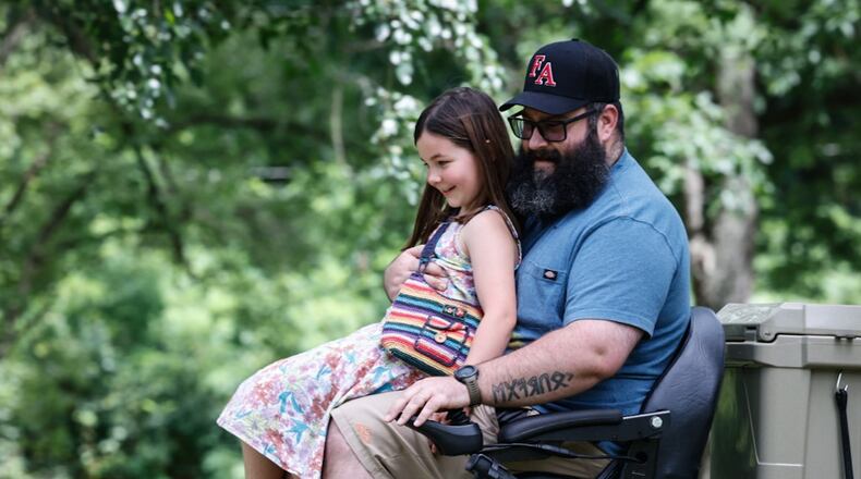 Miamisburg veteran Paul Gibson and his daughter Coralee ride around Crains Run Nature Park Tuesday July 2, after receiving an all-terrain wheelchair from Freedom Alliance a support organization for wounded veterans. JIM NOELKER/STAFF