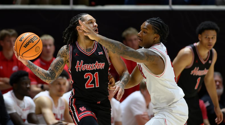 Houston guard Emanuel Sharp, left, looks to pass around the defense of Utah forward Kendyl Sanders, right, during the first half of an NCAA college basketball game, Tuesday, Feb. 10, 2026, in Salt Lake City. (AP Photo/Tyler Tate)