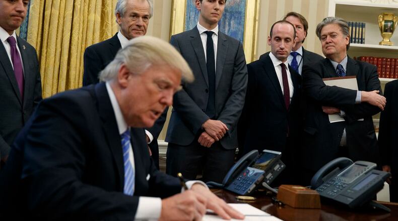 From left, White House Chief of Staff Reince Priebus, National Trade Council adviser Peter Navarro, Senior Adviser Jared Kushner, policy adviser Stephen Miller, and chief strategist Steve Bannon watch as President Donald Trump signs an executive order in the Oval Office of the White House, Monday, Jan. 23, 2017, in Washington. (AP Photo/Evan Vucci)