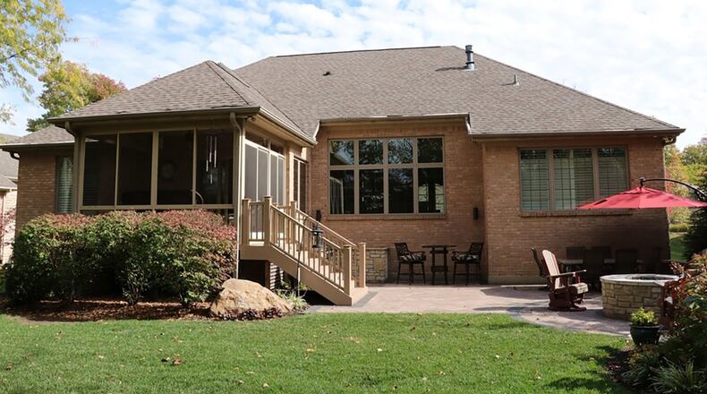 A screen-enclosed porch off the breakfast room leads down to an outdoor kitchen with a paver-stone patio, gas grill nook surrounded by granite and stone counters and a gas fire pit.