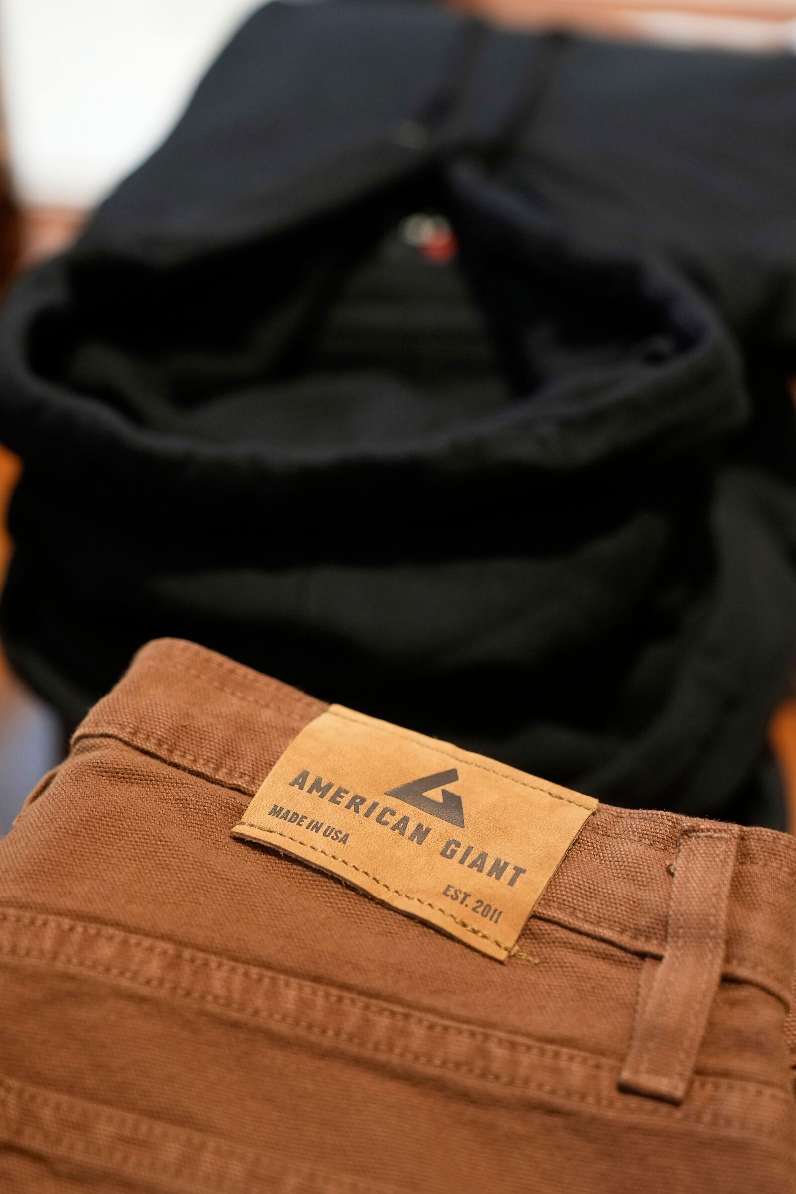 An American Giant logo tag is shown on pants at the company's showroom in San Francisco, Thursday, April 17, 2025. (AP Photo/Jeff Chiu)