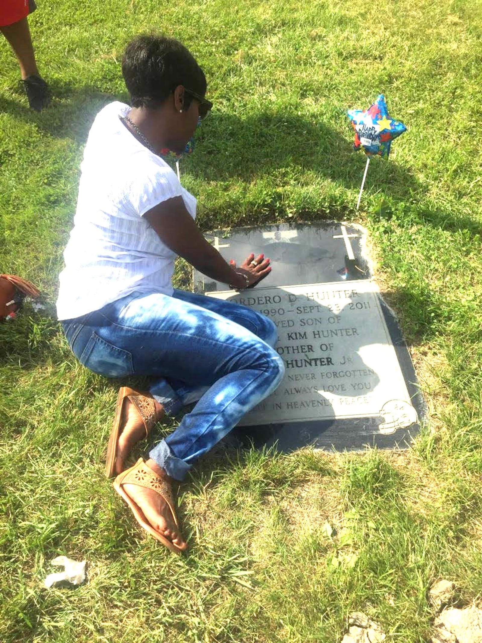 Kim Hunter, Kordero Hunter's mother, lays at his grave in Chicago’s Mt. Greenwood Cemetery. CONTRIBUTED PHOTO