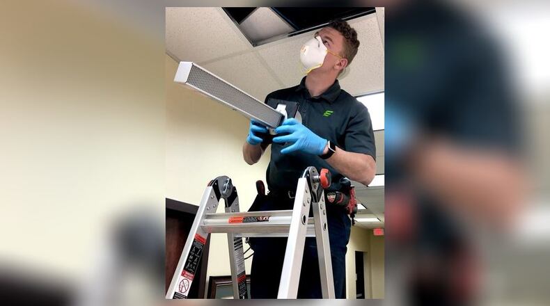 Robbie Mount of Extreme Microbial Technologies installs a technology to help battle the coronavirus. STAFF