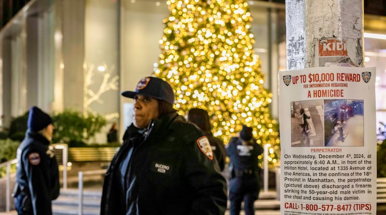FILE — A poster advertising a reward for information is posted near the site where Brian Thompson, chief executive of UnitedHealthcare, was fatally gunned down in midtown Manhattan, Dec. 4, 2024. New details are emerging about Luigi Mangione’s growing impatience with “a capitalist society” and his search for refuge in the mountains of Japan. (Dave Sanders/The New York Times)