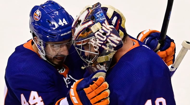 New York Islanders center Jean-Gabriel Pageau (44) celebrates with goaltender Semyon Varlamov (40) after defeating the Philadelphia Flyers in NHL Stanley Cup Eastern Conference playoff hockey game action in Toronto, Saturday, Aug. 29, 2020. (Frank Gunn/The Canadian Press via AP)