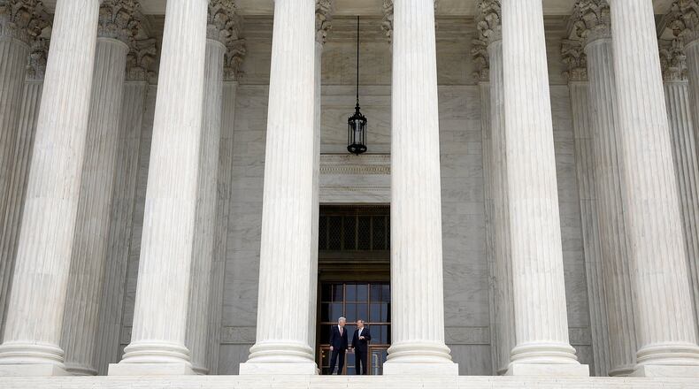 Supreme Court Justice Neil Gorsuch (L) talks with Chief Justice John Roberts (R) on the steps of the Supreme Court following his official investiture at the Supreme Court June 15, 2017, in Washington, DC. (Photo by Win McNamee/Getty Images)
