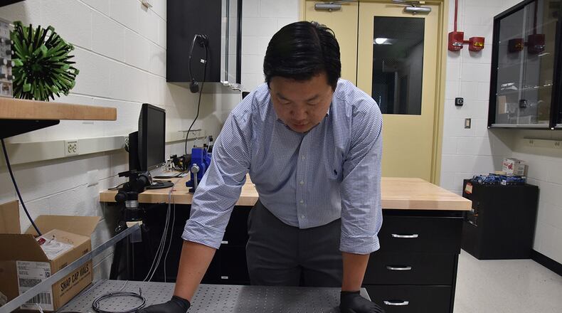 Dr. Vincent Chen, an Air Force Research Laboratory scientist, demonstrates the experimental setup used to trigger shape change in soft, magnetically responsive elastomers. (U.S. Air Force photo/Spencer Deer)