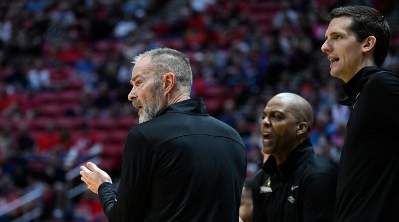 Wright State head coach Scott Nagy, left, stands with assistants by the bench during the first half of a first-round NCAA college basketball tournament game against Arizona, Friday, March 18, 2022, in San Diego. (AP Photo/Denis Poroy)