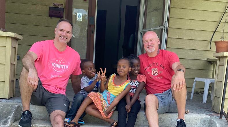Micah and Thomas Thompson sit with children of an immigrant family that their organization, Valens Solutions, assisted in June. Contributed