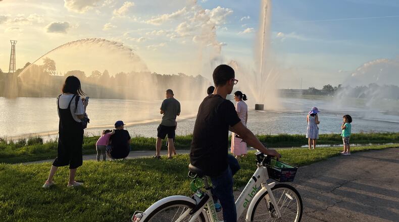 A man rides on one of Link's electric-assisted bicycles by the fountains at RiverScape MetroPark. CORNELIUS FROLIK / STAFF