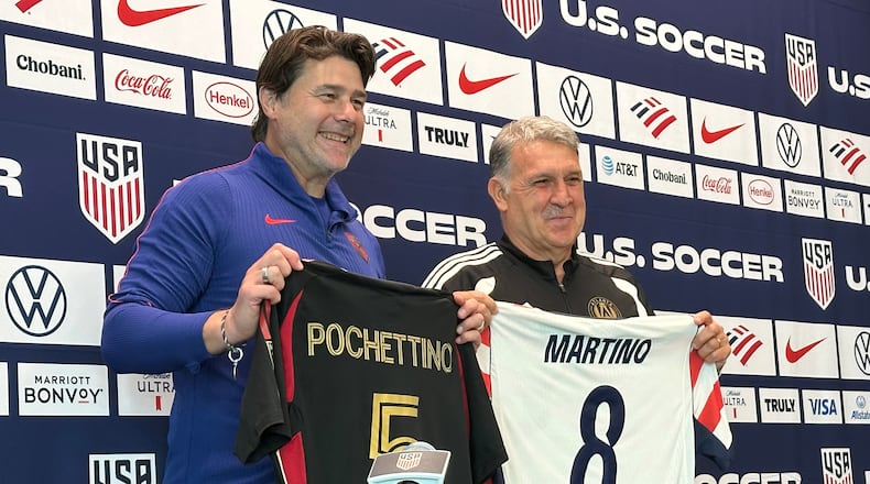 Unites States coach Mauricio Pochettino and Atlanta United coach Tara Martino pose with jerseys during a news conference before the men's national soccer team training, Friday, March 27, 2026, in Marietta, Ga. (AP Photo/Ronald Blum