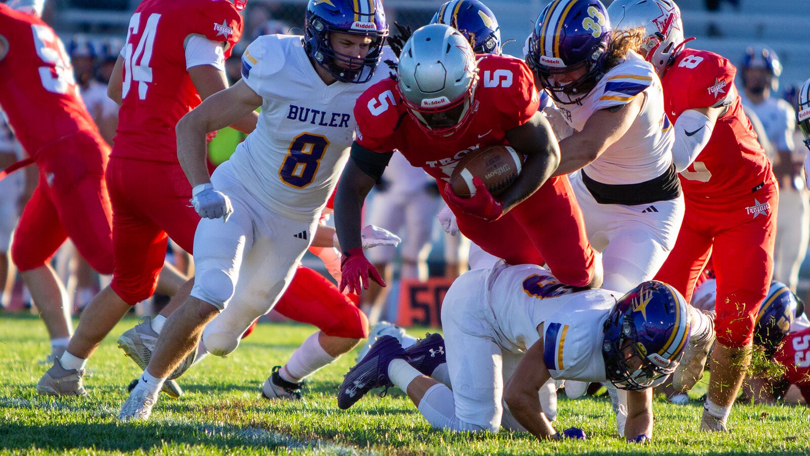 Troy's Jahari Ward dives for yardage against Butler's Austin Flohre (8) and Derek Hobbs (33) as the grass flies at Troy Memorial Stadium on Aug. 31, 2023. Jeff Gilbert/CONTRIBUTED
