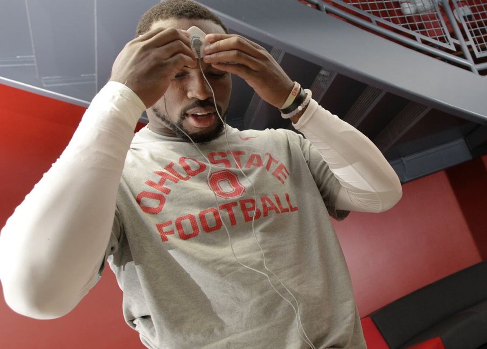 In this Sept. 16, 2015, photo, Ohio State safety Tyvis Powell attaches electrodes to his forehead and hand to start his daily biometrics monitoring before practice in Columbus, Ohio. Ohio State uses the device to track overall physiological readiness of players and how they hold up to the wear and tear of football. (AP Photo/Jay LaPrete)