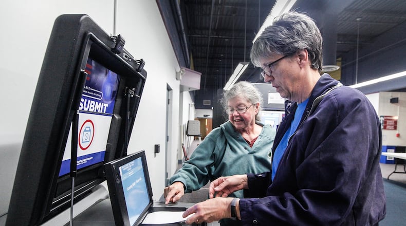 Archive photo: Washington Twp. voter Linda Hunter feeds her ballot into a machine with the help of poll worker Terrie Gutwein at the Washington Twp. Recreation Center. New poll workers are being sought due to concerns of the coronavirus. CHRIS STEWART / STAFF
