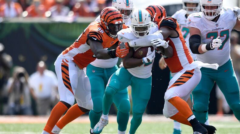 Preston Brown #52 of the Cincinnati Bengals and Carlos Dunlap #96 combine to tackle Kenyan Drake #32 of the Miami Dolphins during the first quarter at Paul Brown Stadium on October 7, 2018 in Cincinnati, Ohio. (Photo by Bobby Ellis/Getty Images)