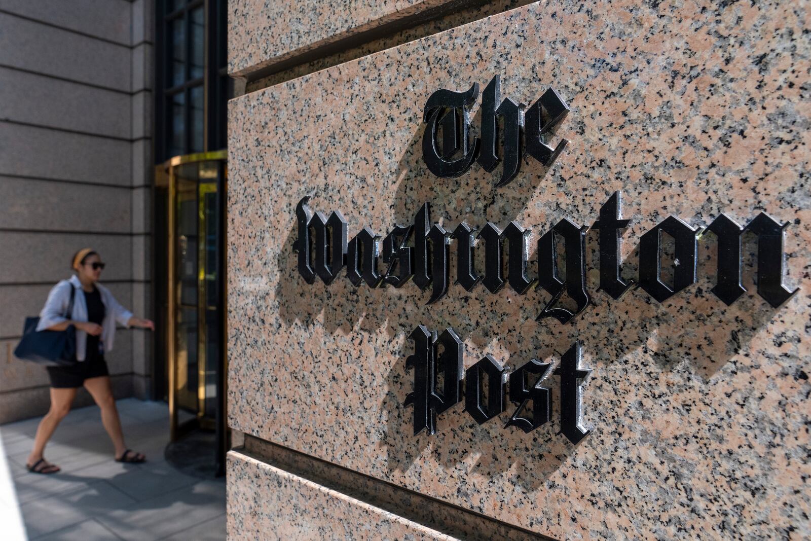 FILE - A person walks into the One Franklin Square Building, home of The Washington Post newspaper, Friday, June 21, 2024, in Washington. (AP Photo/Alex Brandon, File)
