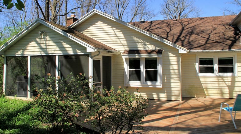 The private back yard has a raised garden bed, wood deck, paver-brick patio and a screen-enclosed porch. A paver-brick walk wraps around to the side yard and ends at the horseshoe driveway.