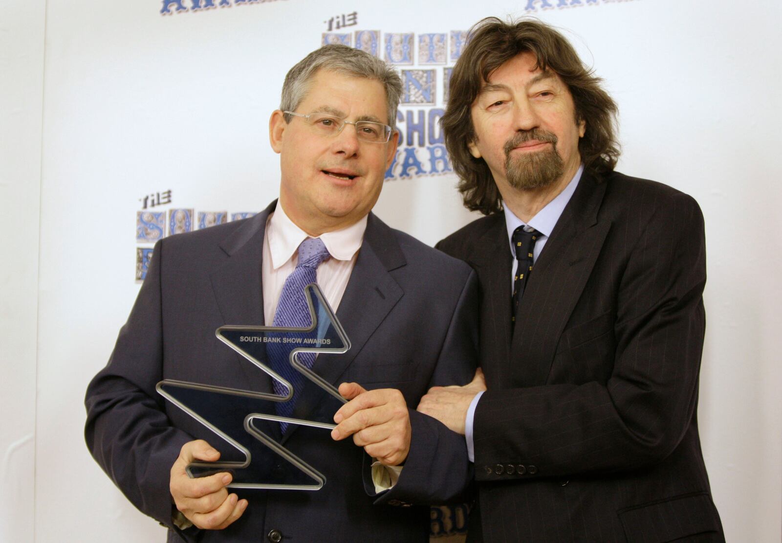 FILE - Cameron Mackintosh, left, holds the Outstanding Achievement Award presented to him by Sir Trevor Nunn in the media room at the South Bank Awards held at a central London hotel, Tuesday, Jan. 20, 2009. (AP Photo/Joel Ryan, File)
