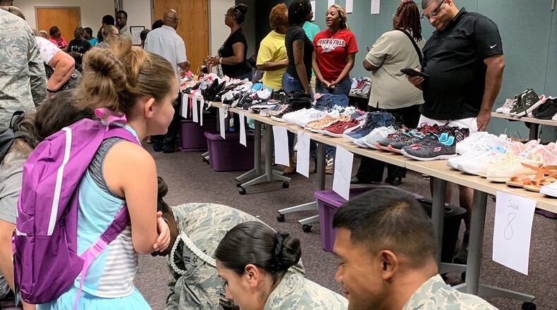 Airmen check the fit of a child’s new shoes Aug. 8 at the Montgomery County Children’s Center. Young personnel from the 88th Security Forces Squadron and the United States Air Force School of Aerospace Medicine at Wright-Patterson Air Force Base helped about 160 kids find their perfect size and style among the brand-new pairs donated by the base’s Chapel community. (Contributed photo)