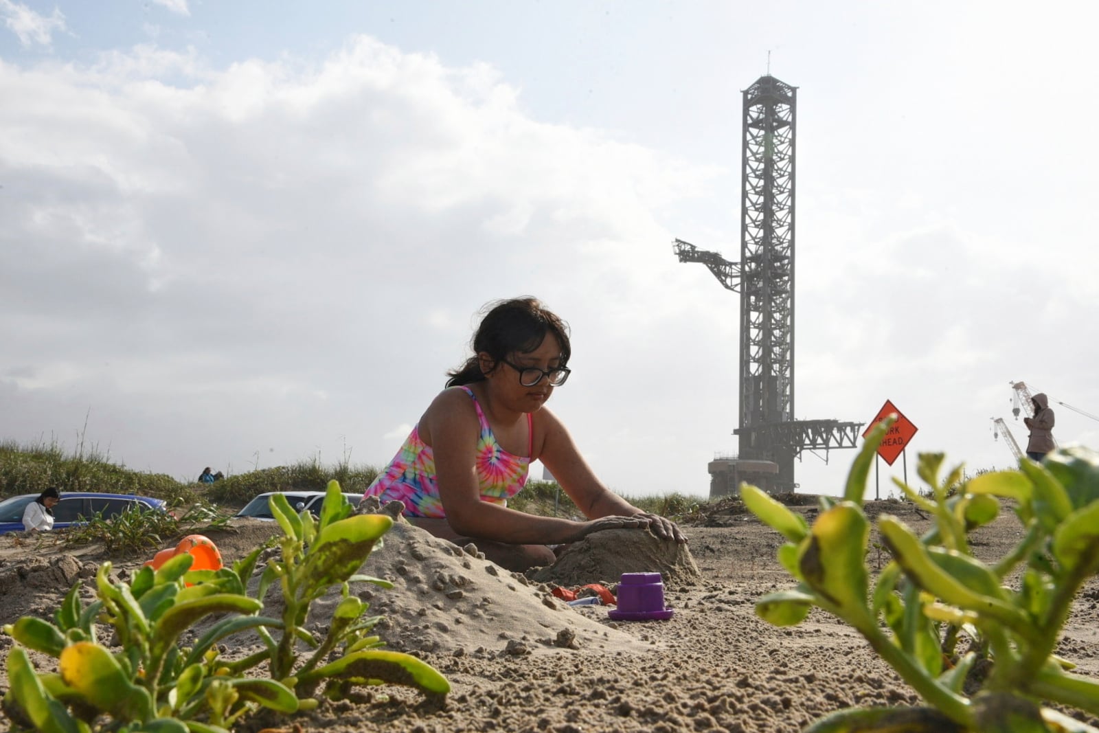 A girl plays in the sand as people protest at Boca Chica beach, Texas, Saturday, May 3, 2025, hours before polls closed for the incorporation election that would turn Starbase into an official Texas city. (AP Photo/Valerie Gonzalez)