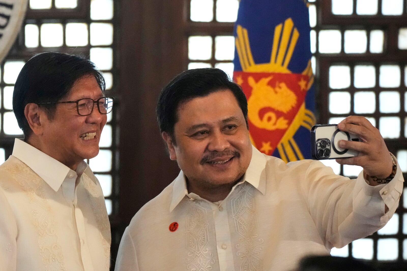 Philippine President Ferdinand Marcos Jr., left, poses for a selfie with Senator Jinggoy Estrada after the presentation of the newly enacted laws to stakeholders at the Malacanang Presidential Palace in Manila, Philippines Thursday, May 22, 2025. (AP Photo/Aaron Favila)