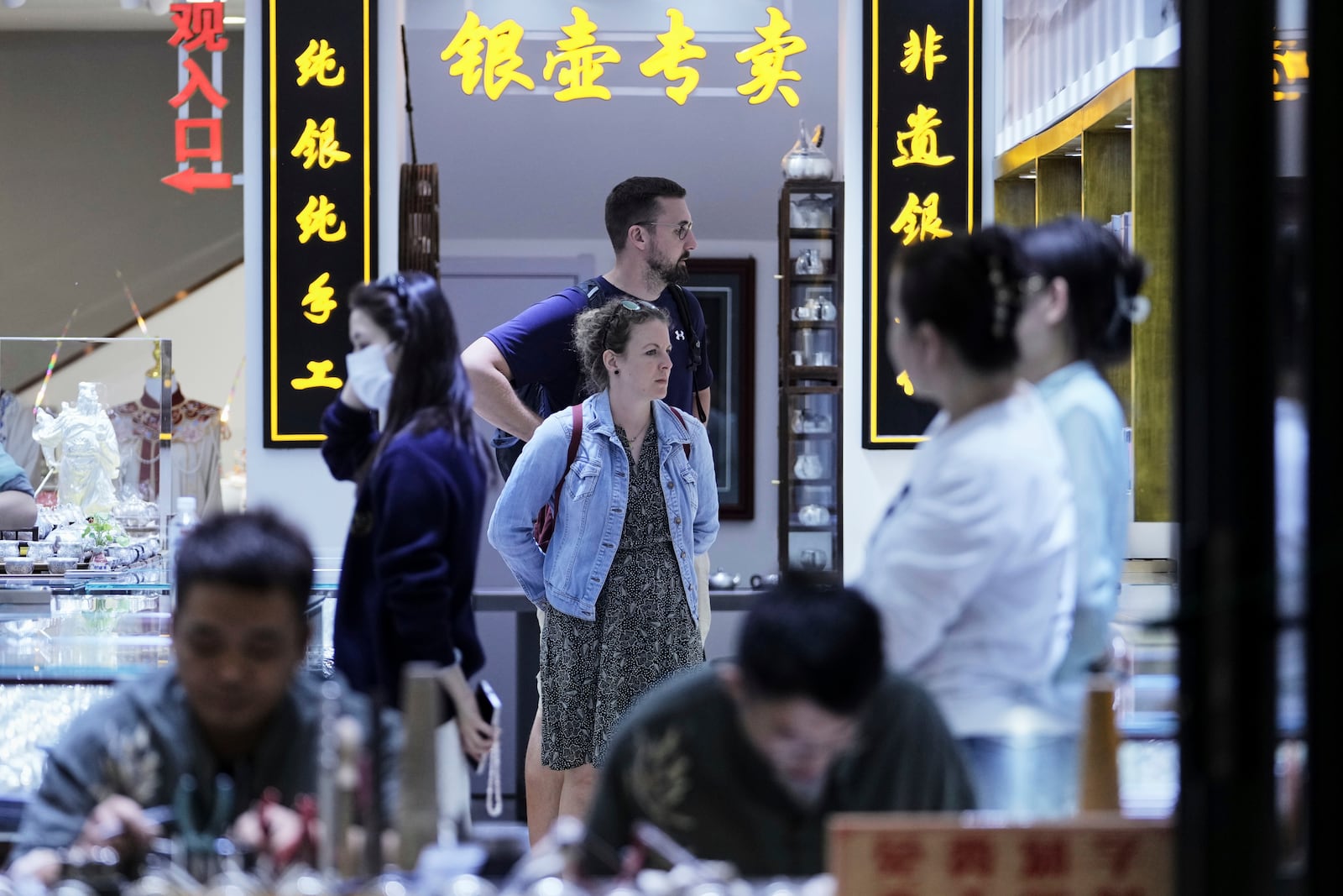 A tourist couple visit a souvenir store at Qianmen pedestrian shopping street in Beijing, Sunday, April 27, 2025. (AP Photo/Andy Wong)