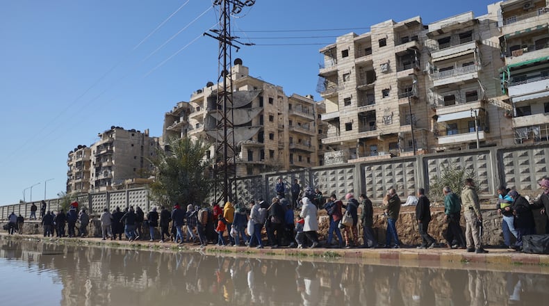 Civilians evacuate an area of the Sheikh Maqsoud neighborhood, where clashes between government forces and Kurdish fighters have been taking place in the northern city of Aleppo, Syria, Saturday, Jan. 10, 2026. (AP Photo/Omar Albam)